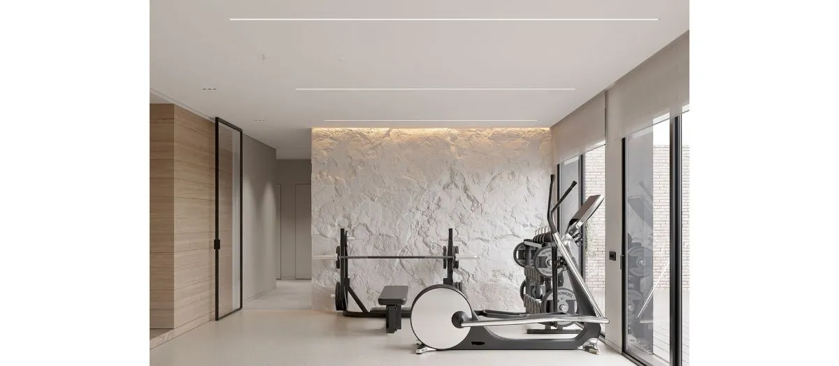 A sleek modern gym featuring a stylish stone wall, creating a unique and motivating workout environment.