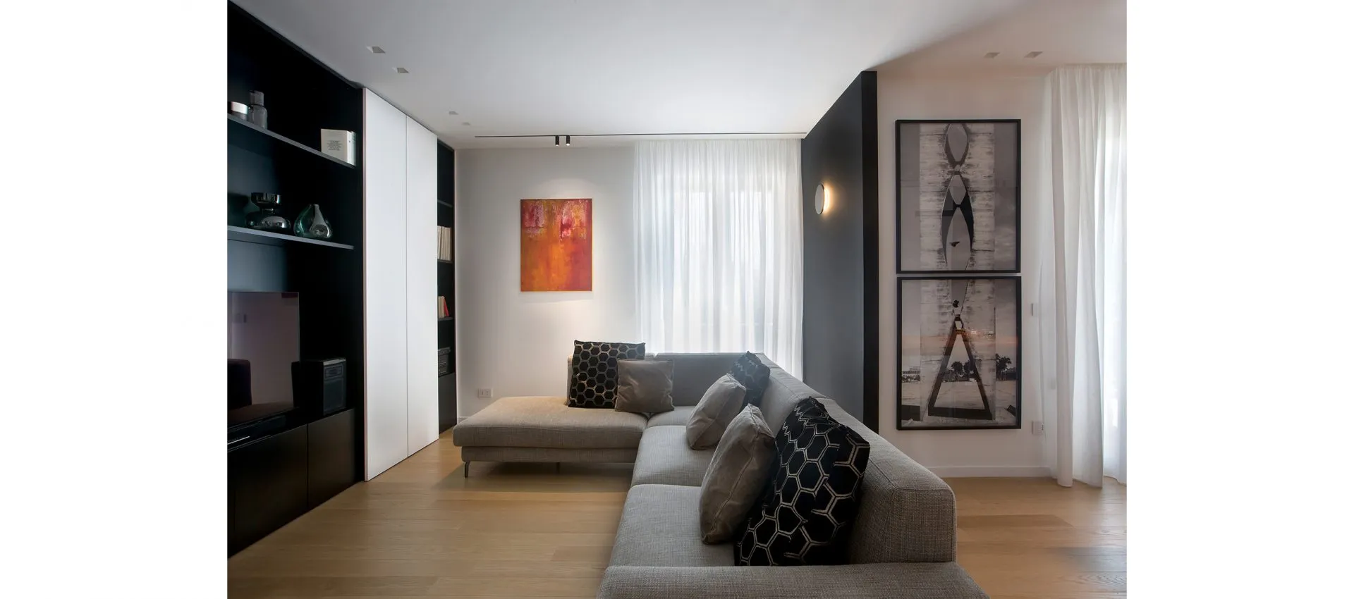 Cozy living room featuring a comfortable couch, a television, and a vibrant painting on the wall, creating a welcoming atmosphere.