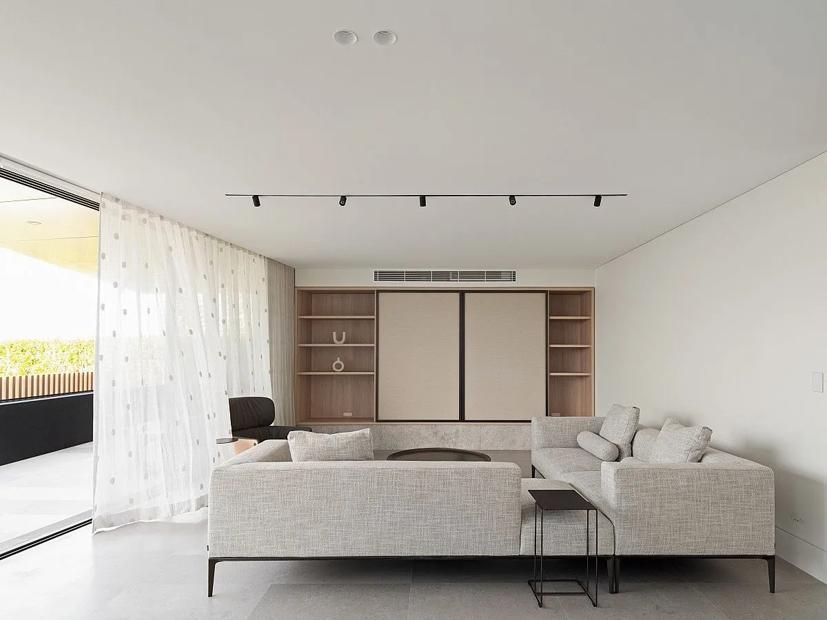 A stylish modern living room featuring a cozy couch and a large sliding glass door that invites natural light.