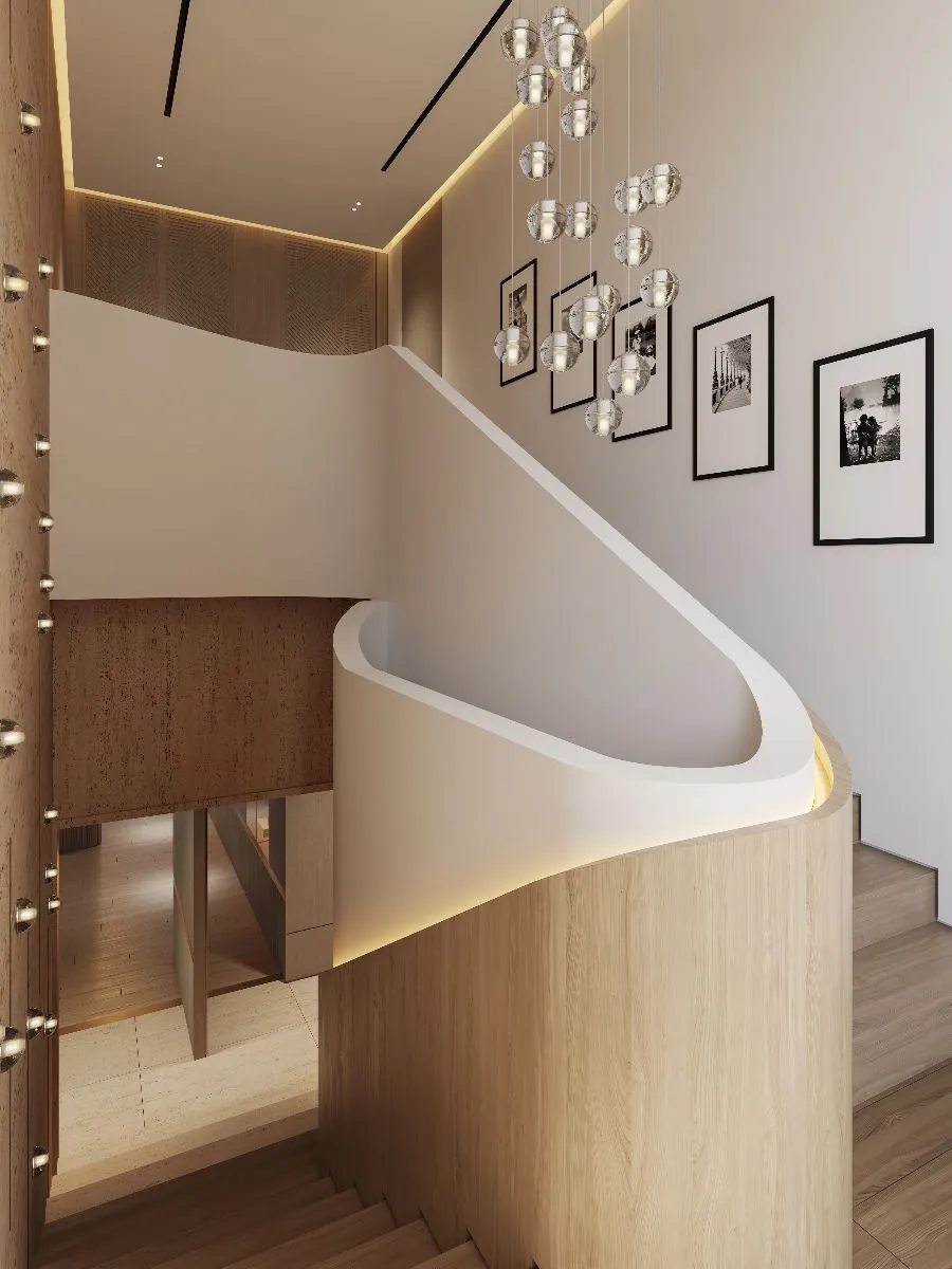 A sleek modern staircase featuring a wooden railing, adorned with framed pictures along the wall, creating a warm atmosphere.
