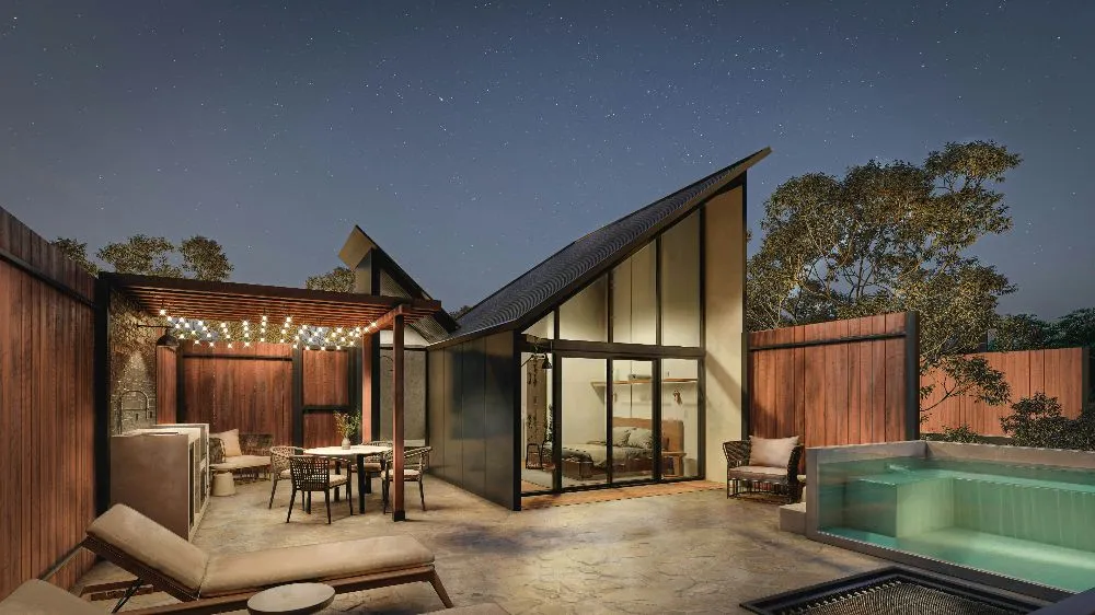 Modern outdoor patio with lighting, furniture, and pool at twilight under starry sky.