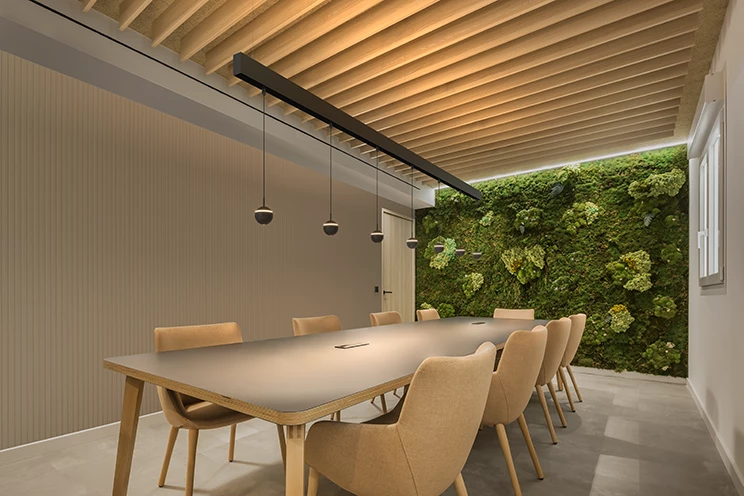 A modern conference room featuring a vibrant green wall and comfortable chairs arranged for a meeting.