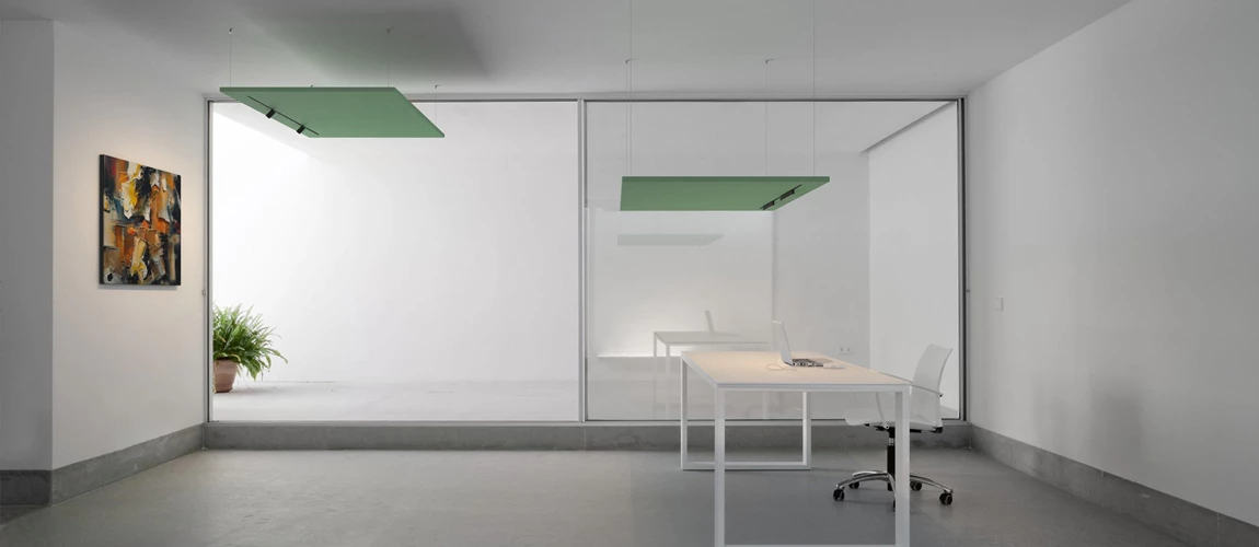 A bright white room featuring a green ceiling and a simple desk, creating a fresh and inviting workspace atmosphere.  
