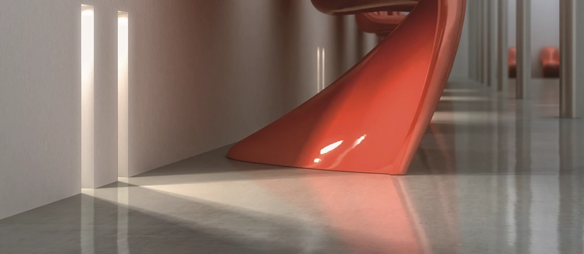 A striking red curved sculpture rests elegantly on the floor, showcasing its smooth lines and vibrant color.