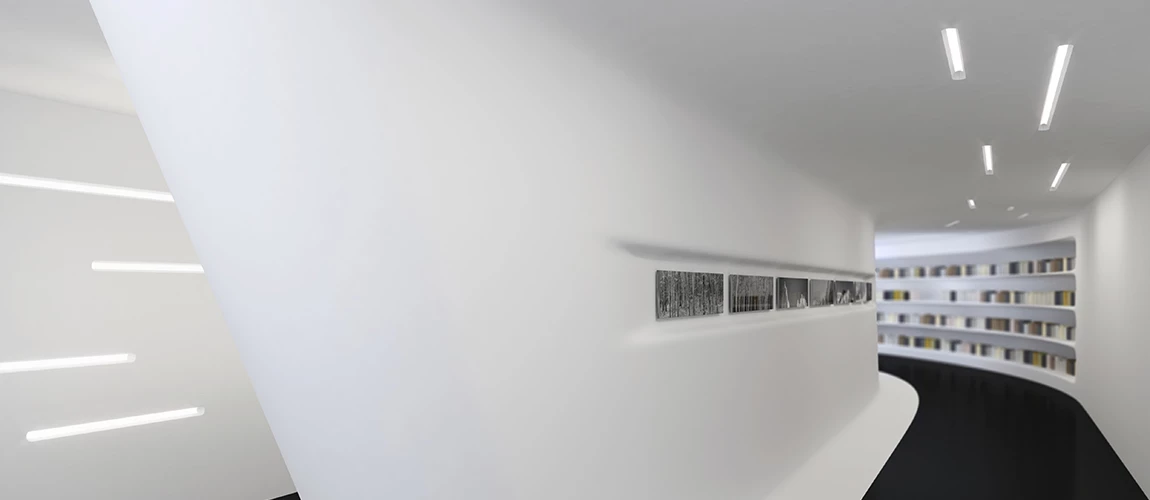 A bright white hallway lined with bookshelves, featuring a striking black and white wall design. 